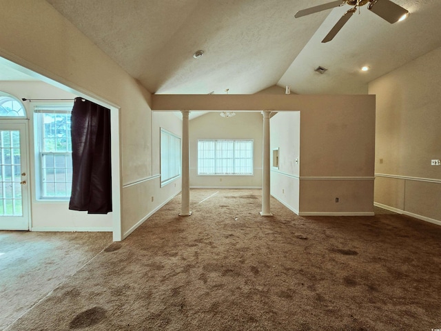 unfurnished room featuring vaulted ceiling, carpet, a ceiling fan, baseboards, and a textured ceiling