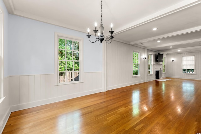 54 River Birch Ln, Pawleys Island, SC 29585 - unfurnished dining area featuring a chandelier, light wood-type flooring, a fireplace with flush hearth, wainscoting, and beam ceiling