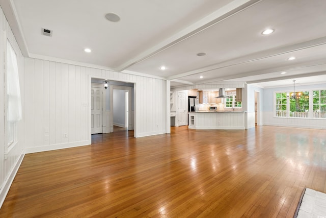 54 River Birch Ln, Pawleys Island, SC 29585 - unfurnished living room with beamed ceiling, a chandelier, light wood-type flooring, and baseboards