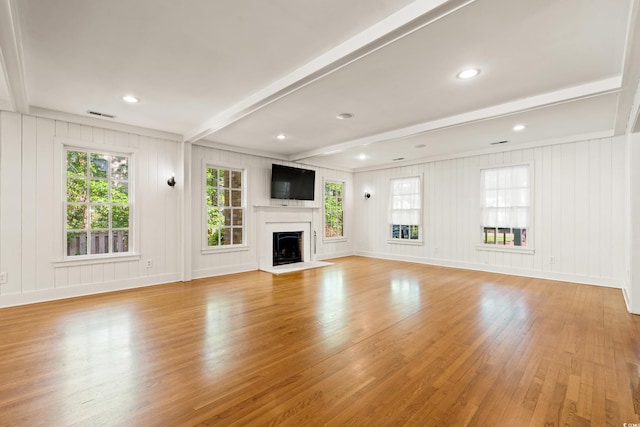 54 River Birch Ln, Pawleys Island, SC 29585 - unfurnished living room featuring light wood-style floors, a decorative wall, beam ceiling, a fireplace, and baseboards