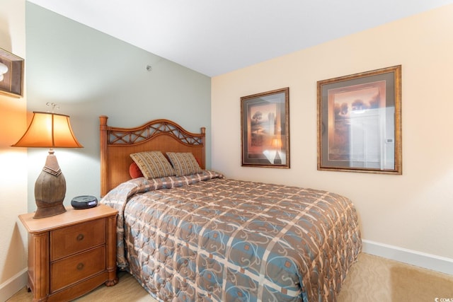 bedroom with baseboards and light colored carpet