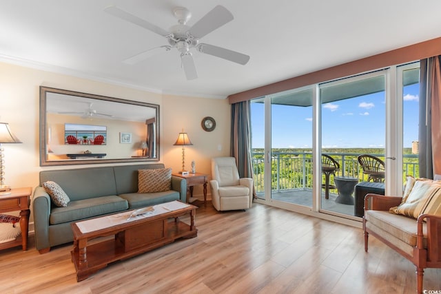living area featuring a ceiling fan, ornamental molding, and light wood-style floors