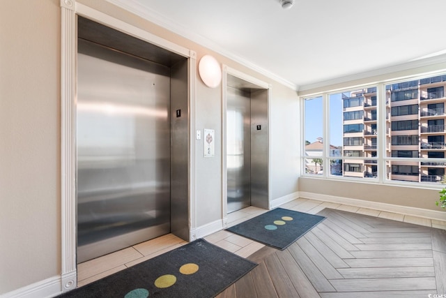 bathroom featuring elevator, ornamental molding, and baseboards