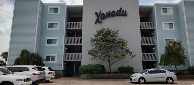 view of apartment building / complex featuring uncovered parking