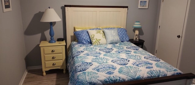 bedroom featuring wood finished floors and baseboards