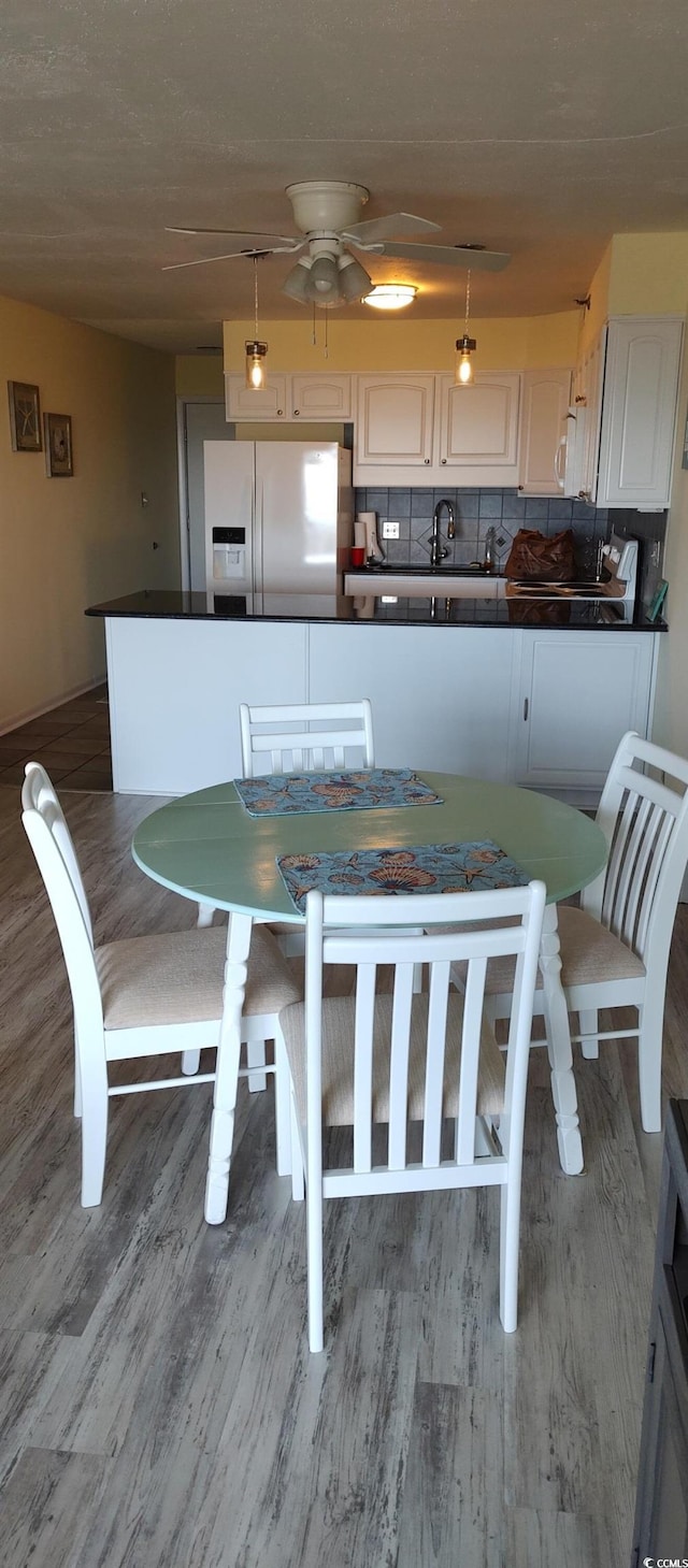 dining space with wood finished floors and a ceiling fan