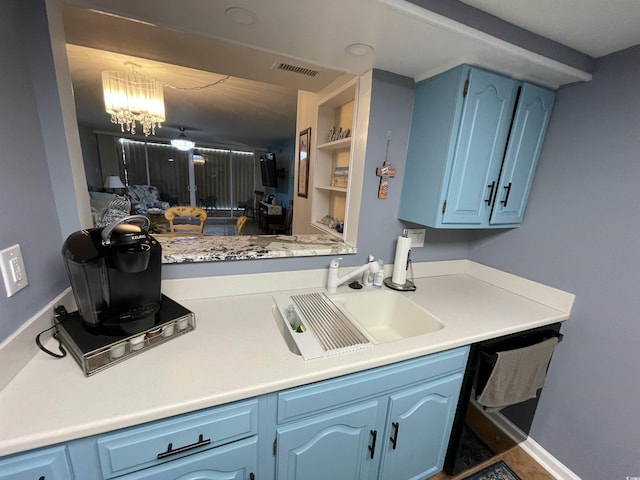 9500 Shore Dr Unit 17B, Myrtle Beach, SC 29572 - kitchen with blue cabinetry, dishwasher, light countertops, and a chandelier