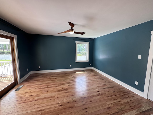 unfurnished room with light wood finished floors, a ceiling fan, and baseboards