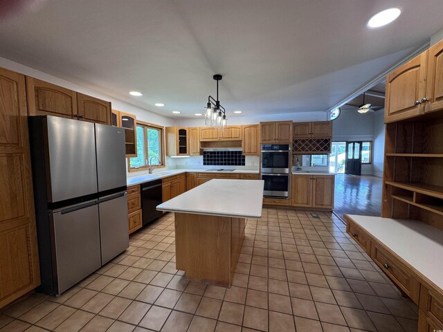 kitchen featuring black appliances, plenty of natural light, glass insert cabinets, light countertops, and recessed lighting