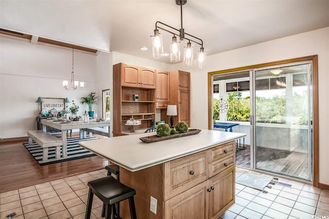kitchen with light tile patterned floors, a chandelier, open shelves, light countertops, and a kitchen island