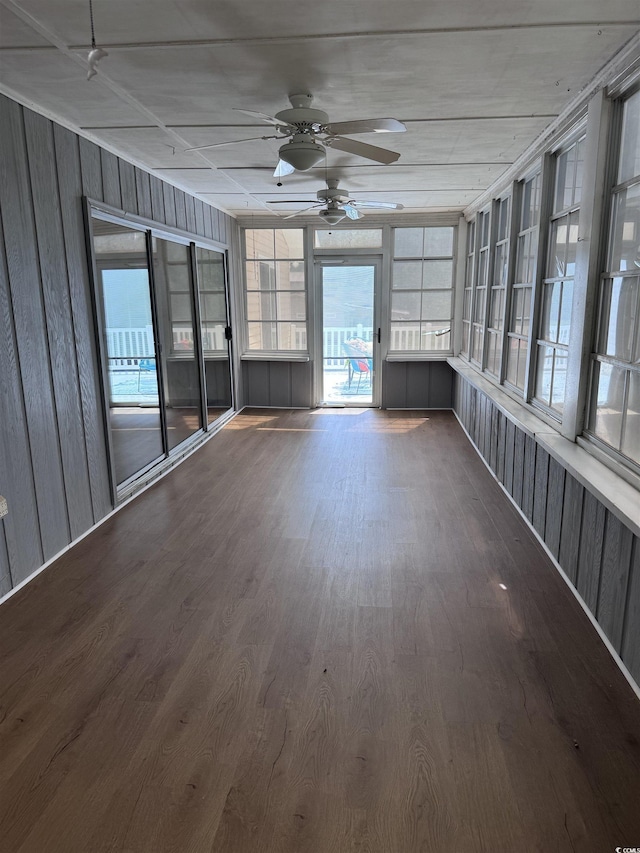 unfurnished sunroom featuring a ceiling fan