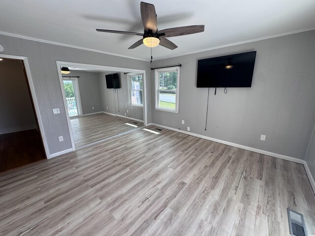 unfurnished living room with a ceiling fan, crown molding, baseboards, and wood finished floors