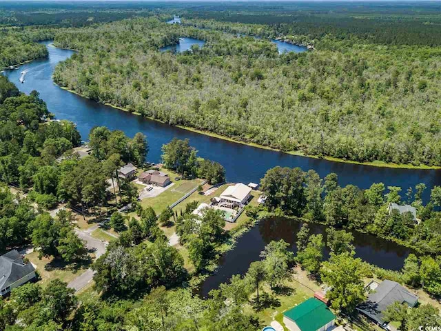 drone / aerial view of a heavily wooded area and a nearby body of water