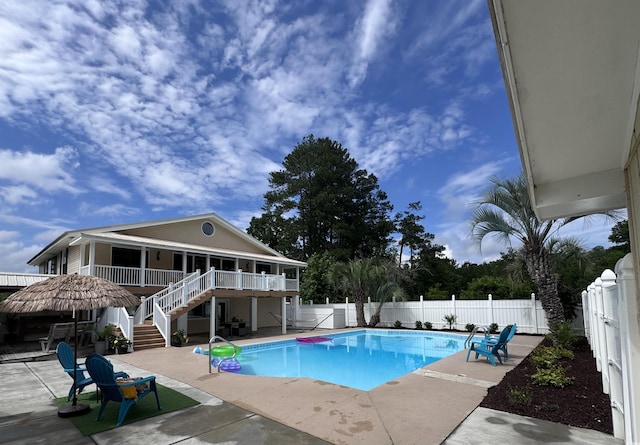view of swimming pool featuring stairs, a fenced backyard, a patio, and a wooden deck