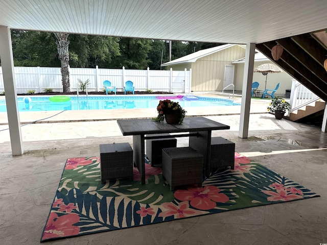 view of swimming pool featuring a patio area, a fenced backyard, and outdoor dining space