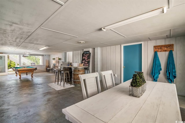 dining area featuring concrete flooring, pool table, and a dry bar