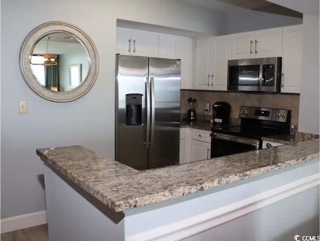 3000 Ocean Blvd N Unit 508, Myrtle Beach, SC 29577 - kitchen with appliances with stainless steel finishes, tasteful backsplash, light stone counters, white cabinetry, and baseboards