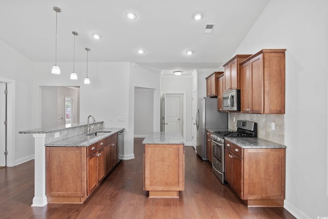 kitchen with appliances with stainless steel finishes, a sink, baseboards, a peninsula, and recessed lighting