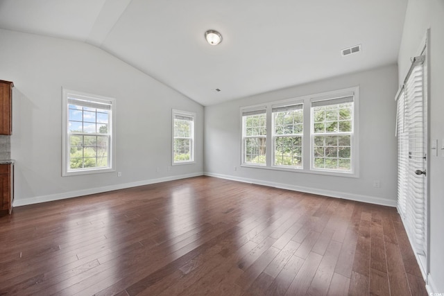 unfurnished living room featuring lofted ceiling, dark wood-type flooring, and baseboards