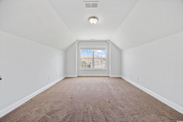 bonus room featuring light carpet, lofted ceiling, and baseboards