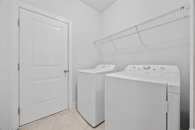 washroom featuring washer and dryer and baseboards