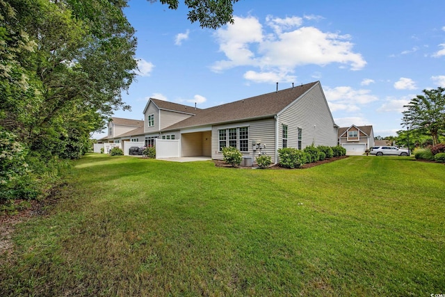 rear view of house with a patio, a yard, and roof with shingles
