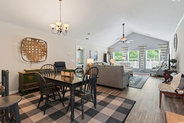 dining room with ceiling fan, lofted ceiling, a chandelier, and wood finished floors