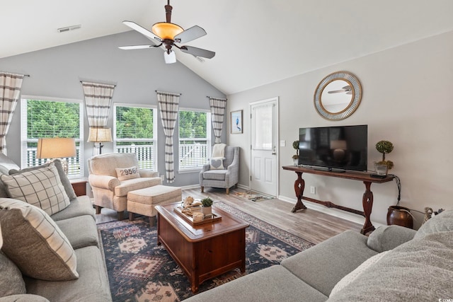 living area featuring ceiling fan, wood finished floors, baseboards, and high vaulted ceiling