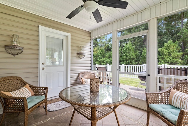 sunroom / solarium featuring outdoor dining space, a ceiling fan, and healthy amount of natural light