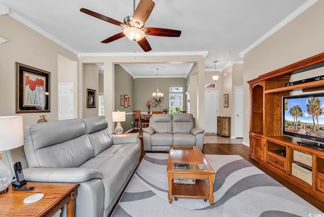 living area featuring a ceiling fan, crown molding, wood finished floors, a chandelier, and baseboards