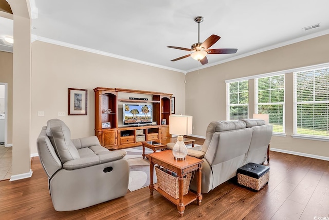living area featuring crown molding, ceiling fan, wood finished floors, and baseboards