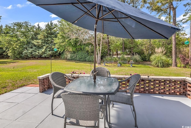 view of patio / terrace featuring outdoor dining area and view of wooded area