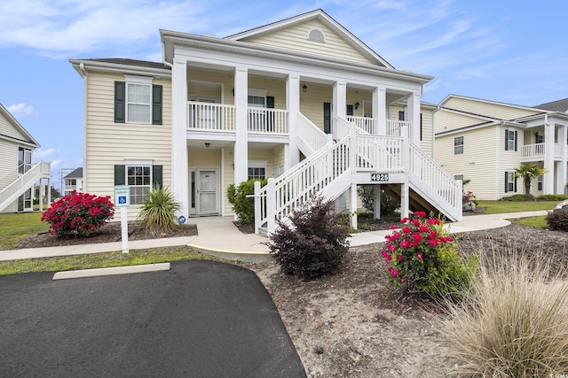4925 Pond Shoals Ct Unit 202, Myrtle Beach, SC 29579 - greek revival house with stairway, a porch, and uncovered parking