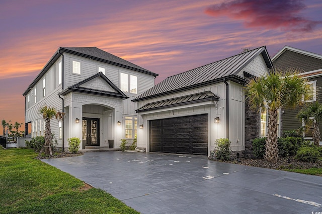 view of front of home with concrete driveway, french doors, a standing seam roof, a garage, and metal roof