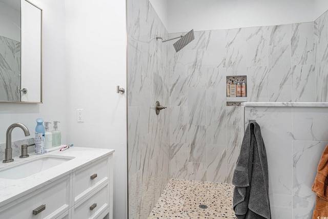full bath featuring vanity and a marble finish shower