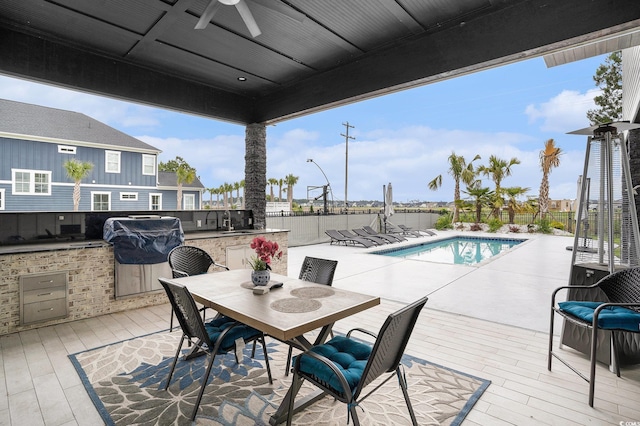 view of swimming pool featuring area for grilling, a ceiling fan, fence, and a wooden deck