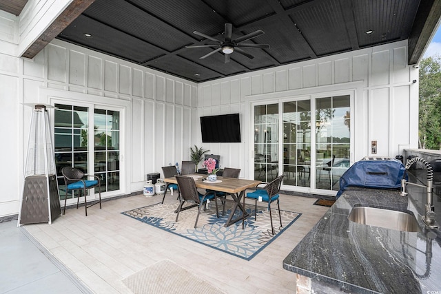 view of patio featuring a ceiling fan, outdoor dining space, and a sink