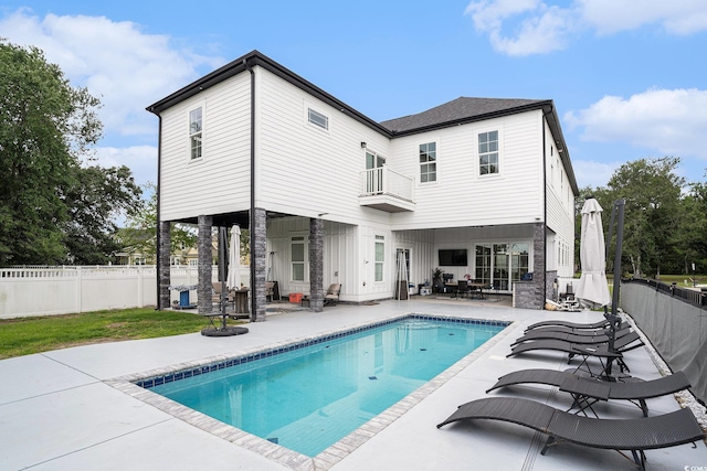 rear view of house with a patio area, a balcony, and a fenced backyard