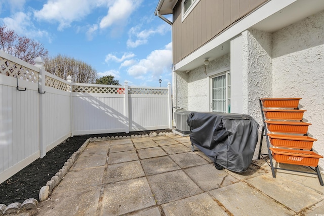 view of patio / terrace featuring area for grilling, cooling unit, and a fenced backyard