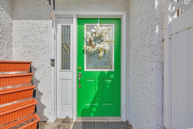 doorway to property featuring stucco siding