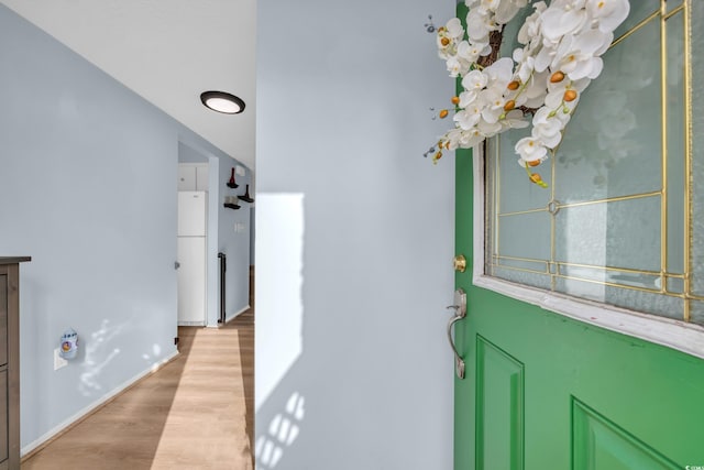 foyer entrance featuring light wood finished floors and baseboards