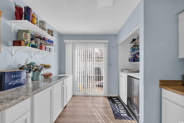 washroom with washing machine and clothes dryer and light wood-style floors