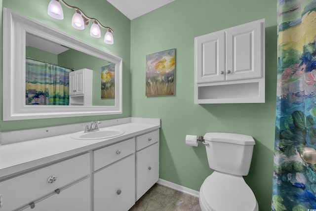 bathroom with baseboards, vanity, and toilet