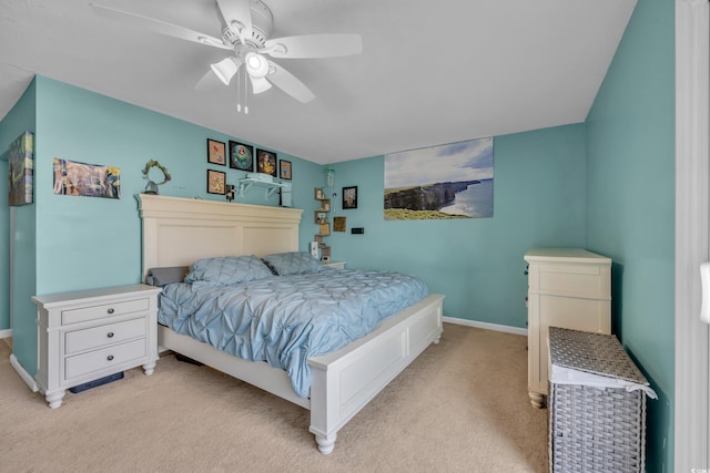 bedroom featuring light colored carpet, baseboards, and a ceiling fan