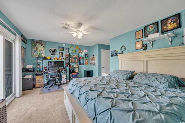bedroom with light carpet, an office area, a textured ceiling, and a ceiling fan