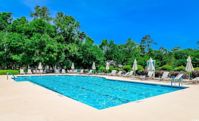 1206 Spinnaker Dr, North Myrtle Beach, SC 29582 - community pool featuring a patio and view of wooded area
