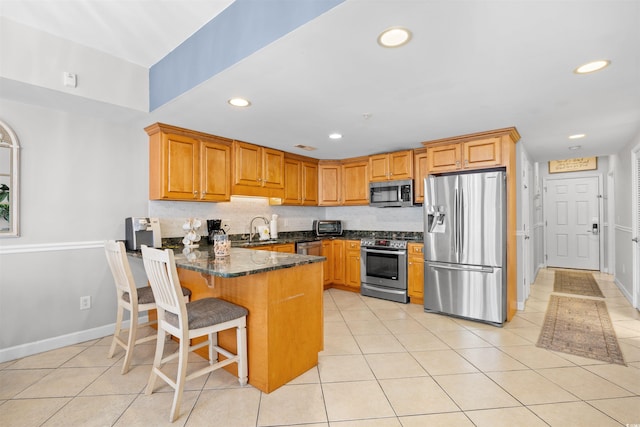 3401 N Ocean Blvd Unit 309, North Myrtle Beach, SC 29582 - kitchen featuring stainless steel appliances, a sink, a peninsula, recessed lighting, and light tile patterned flooring