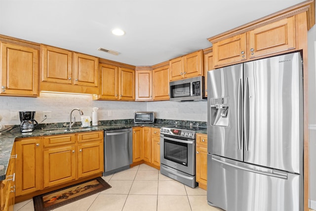 3401 N Ocean Blvd Unit 309, North Myrtle Beach, SC 29582 - kitchen with appliances with stainless steel finishes, a sink, light tile patterned floors, backsplash, and dark stone counters
