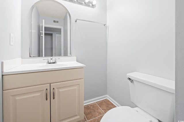 half bath featuring toilet, vanity, and baseboards