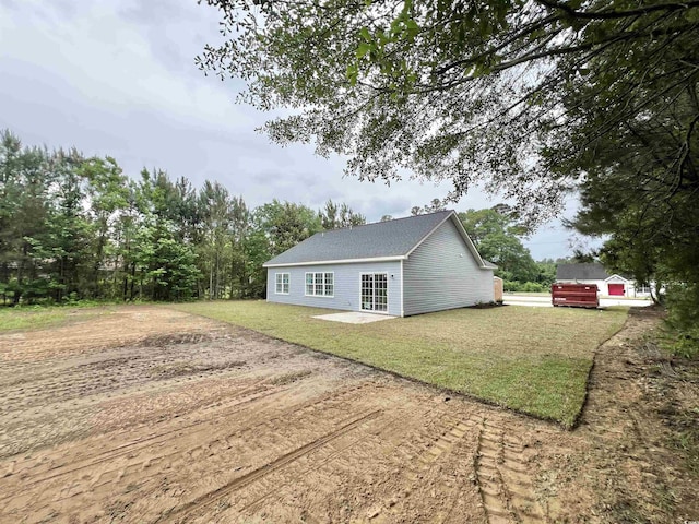 2593 Main St, Loris, SC 29569 - view of home's exterior with dirt driveway, a lawn, and roof with shingles